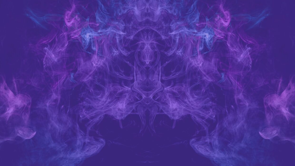 An abstract image featuring swirling clouds of purple and blue smoke on a dark background, creating a symmetrical pattern.